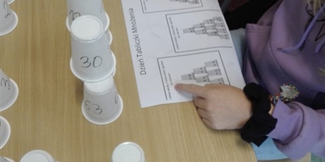 Powiększ grafikę: Uczniowie grają w grę polegającą na układaniu kubeczków na czas według ustalonego modelu.Zadania dotyczą tabliczki mnożenia.